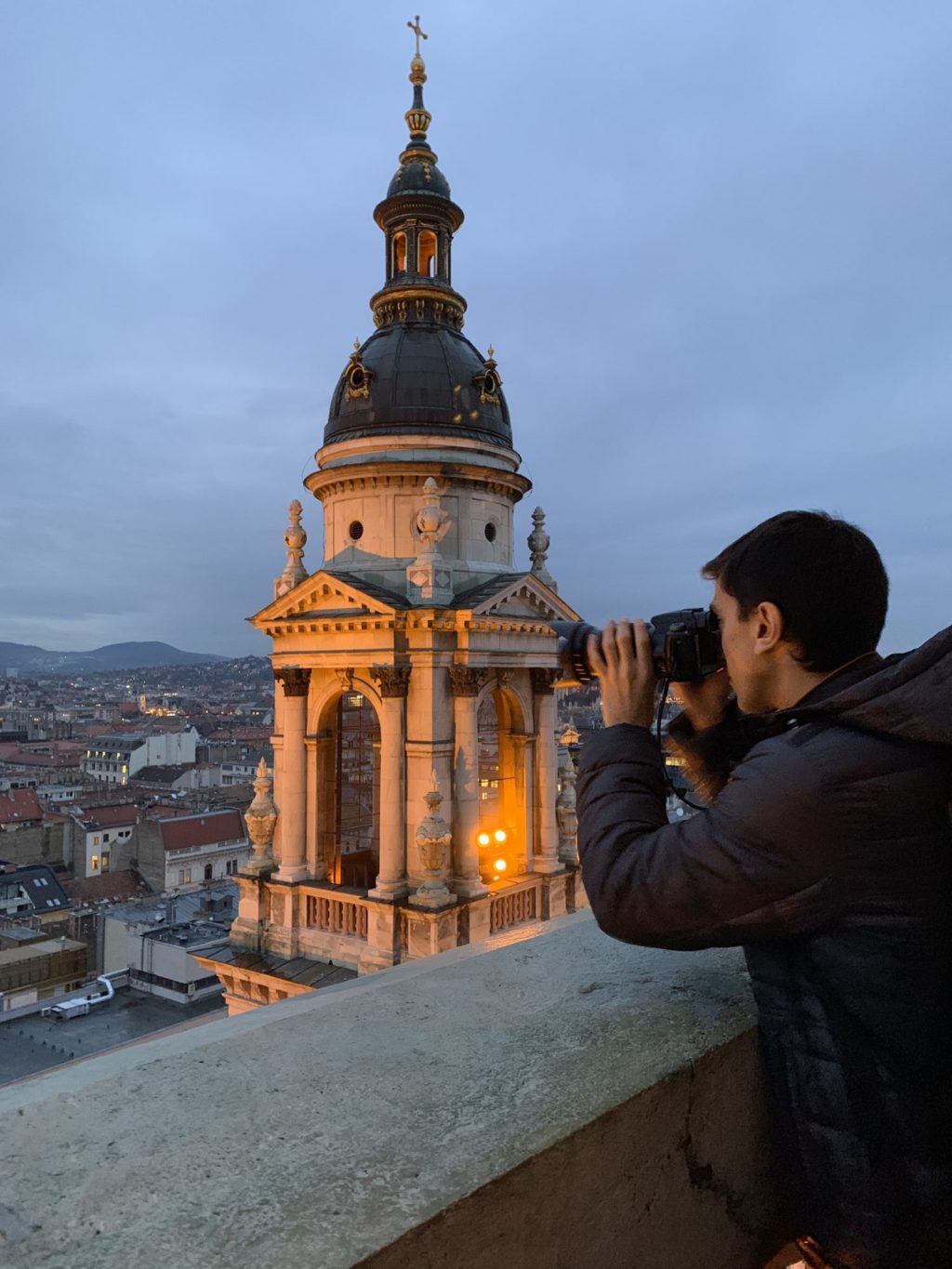 Nicolas looking through his camera in to a European landscape