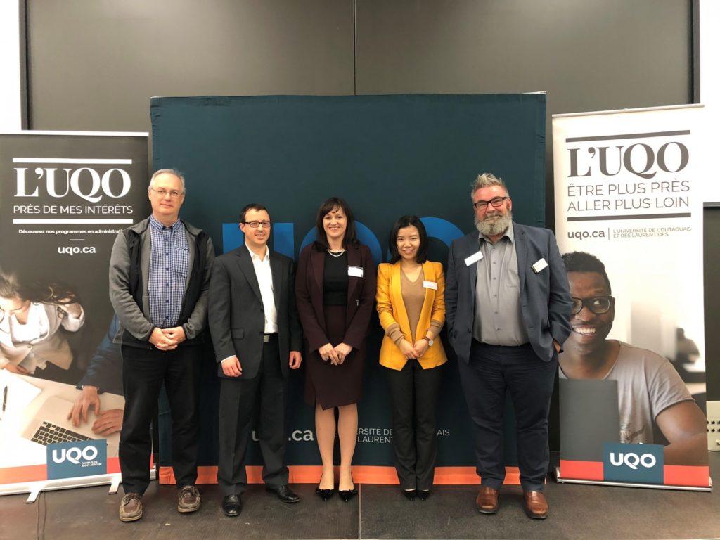 Professor François Brouard, Marc Pilon, Lucille Perreault, Dora Wang and Professor Michel Rod pose in front of a banner