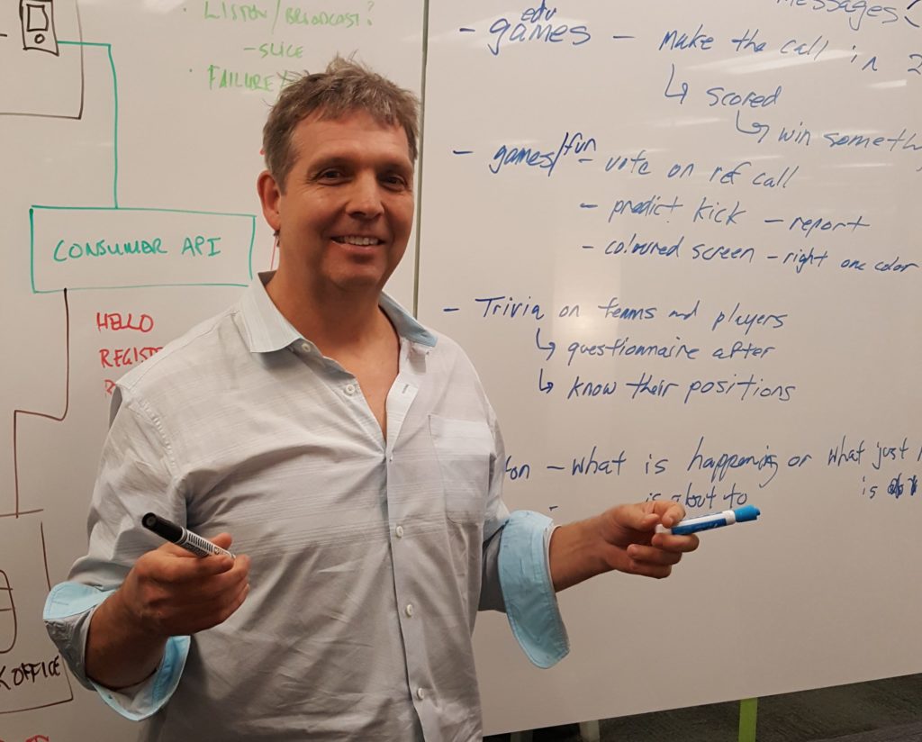 Steve Doswell holding markers in front of a whiteboard