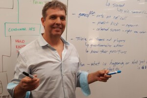 Steve Doswell holding markers in front of a whiteboard