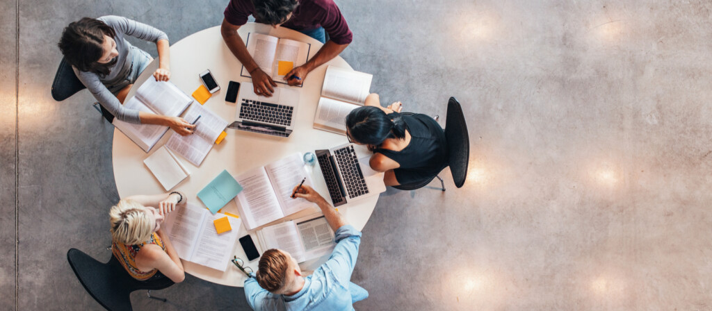 an arial view of 5 students working at a round table
