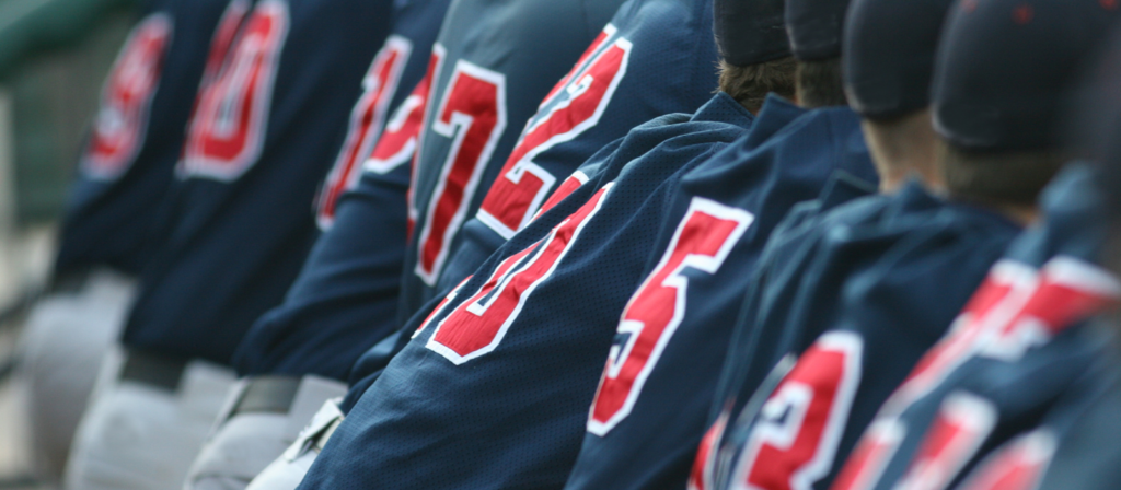 Showing the backs of players on a sports team wearing numbered jerseys.