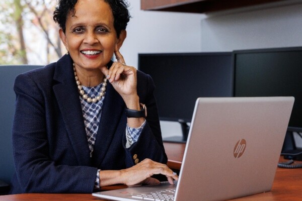 Uma Gupta at a desk with a computer