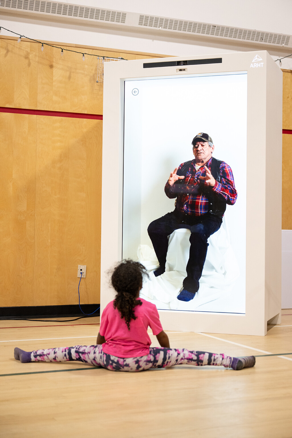 A child watching an elder on the hologram