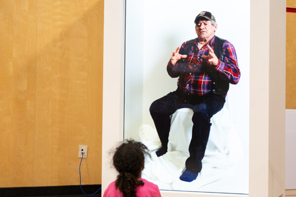 A child watching an elder on the hologram