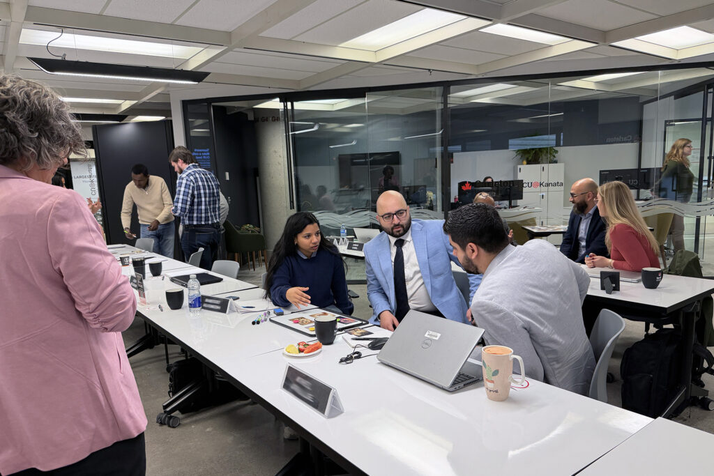 Sprott Associate Dean Luciara Nardon looks on as a group of professional MBA students brainstorm together.