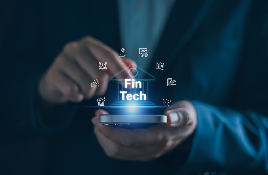 Business professional holding a mobile device illuminated with financial icons.