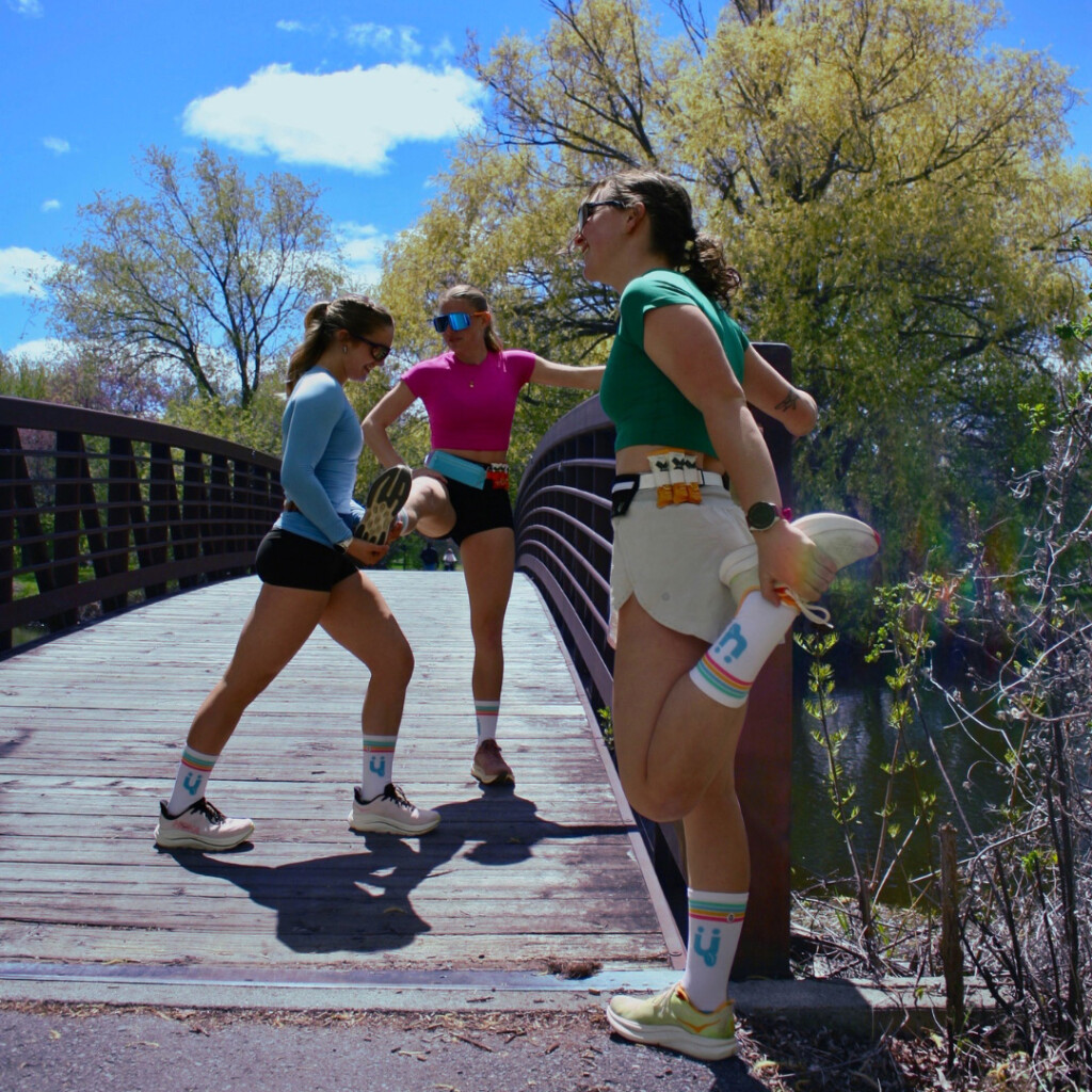 A group of runners wearing the KRuZ Running belt stretching.