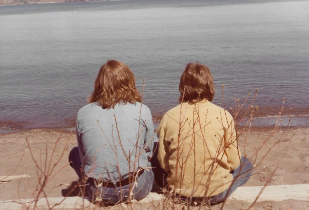 A picture of Nicolas and Irinela's backs as they sit and stare out at water. 