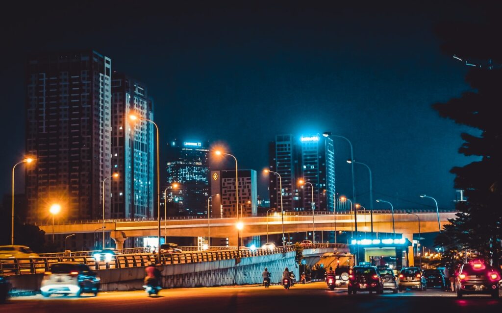 Urban city at night with tall buildings and traffic