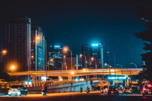 Urban city at night with tall buildings and traffic