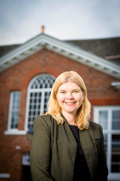 Dana Brown in front of a school