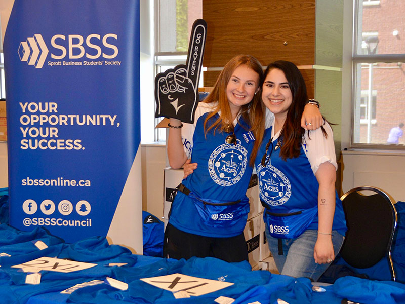 Emily Buchkowsky and a fellow student posing in SBSS gear and with SBSS paraphernalia. 