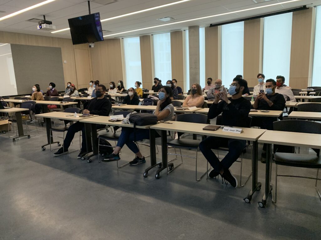 Students sitting on chairs at desks in a classroom in the Nicol Building. They are wearing face masks.