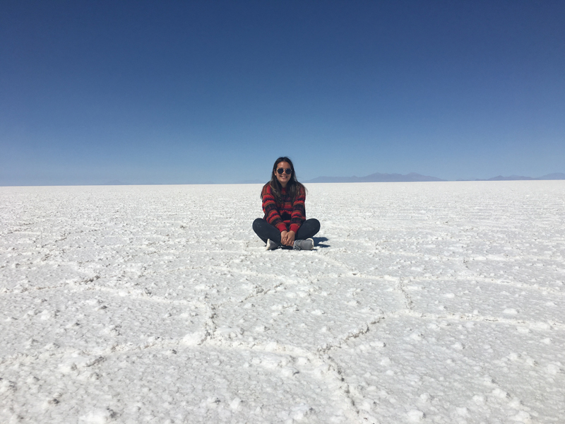Alexndra sitting in the middle of the salt lands with a clear blue sky