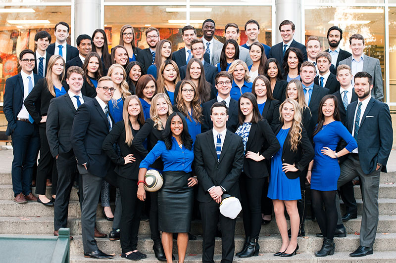 A large group of students in blue and black business attire from Carleton University's Sprott School of Business in Ottawa, Canadda.