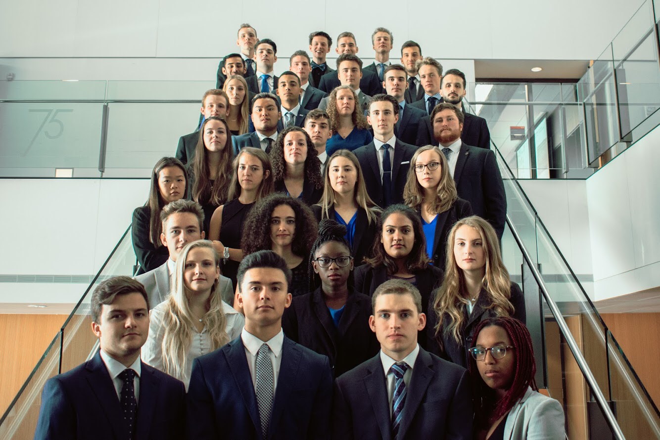 JDCC Sprott team delegates in business attire, arranged on a staircase