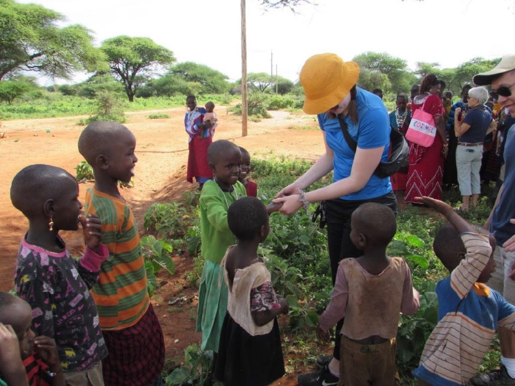 Kennedy Lichti, a fourth-year Bachelor of Commerce student speaking with some Maasai children in Tanzania.