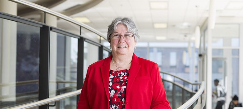 Merridee Bujaki in the Tory atrium wearing a red jacket.