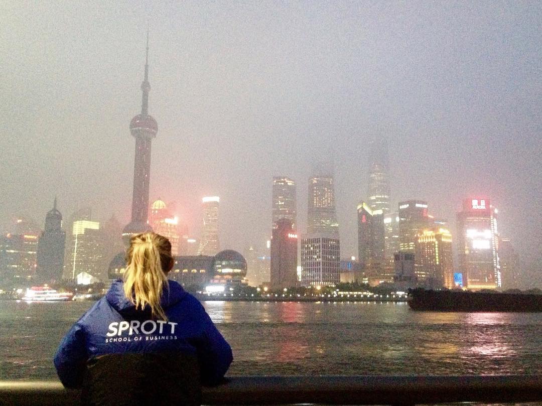 Sophia in a Sprott sweater looking out at the Shanghai skyline