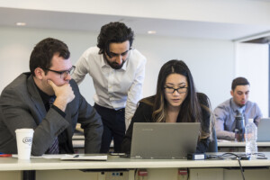 Diverse group of Sprott students working together on a project.