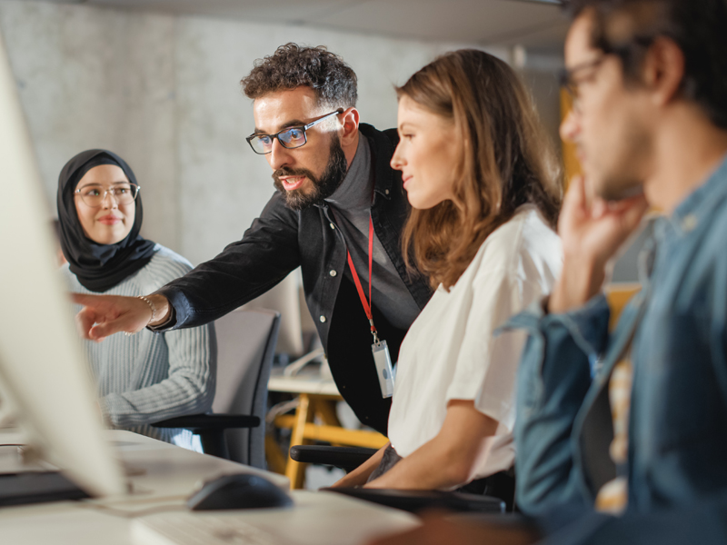 Instructor with students at a computer