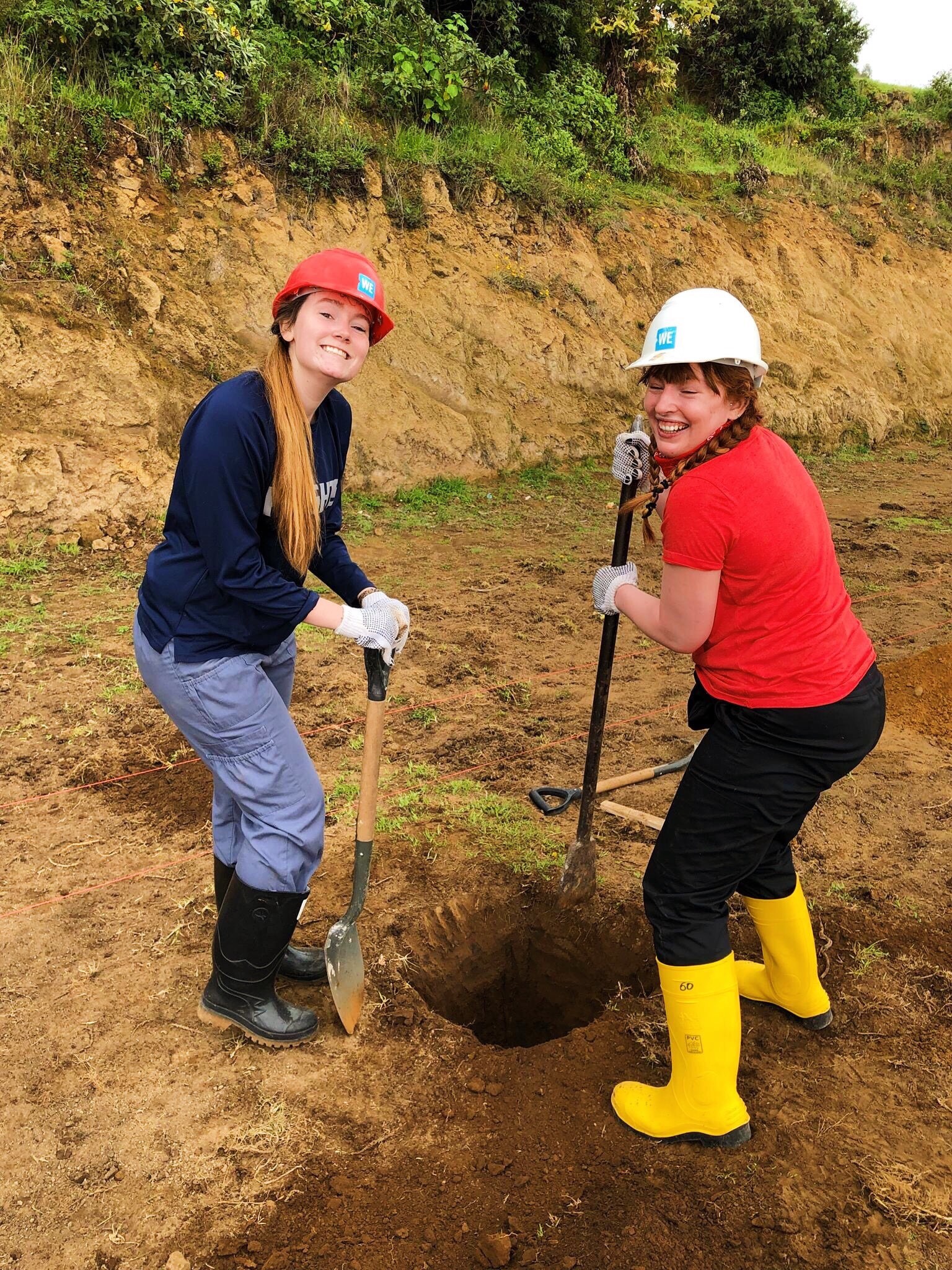 Kiana (right) pictured with group members digging a hole in the ground to be used as the foundation of a greenhouse.