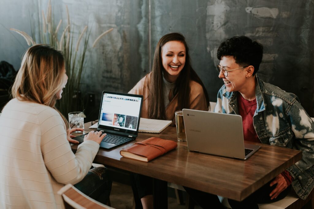 Three people on laptops at a table