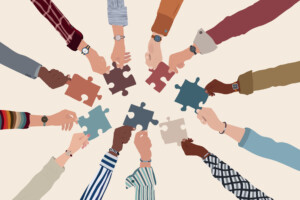 Group of multicultural business people with raised arms holding a puzzle piece.