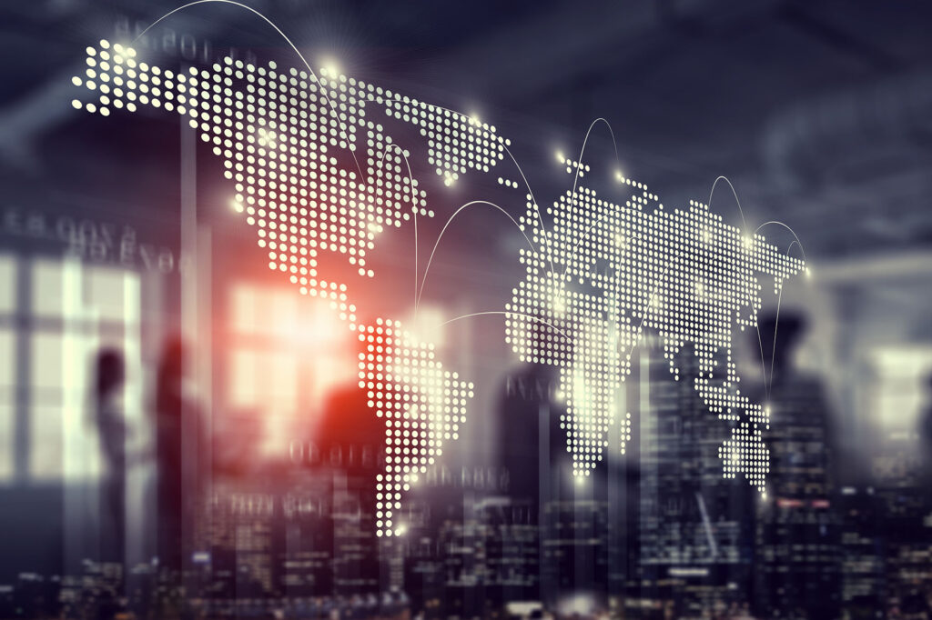 meeting of a group of people silhouetted behind an illuminated world map