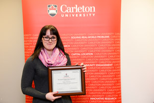 Photo of student Erin Oldford accepting award on professor Isaac Otchere's behalf.