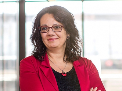 Luciara Nardon smiling and looking to the side with her arms crossed.