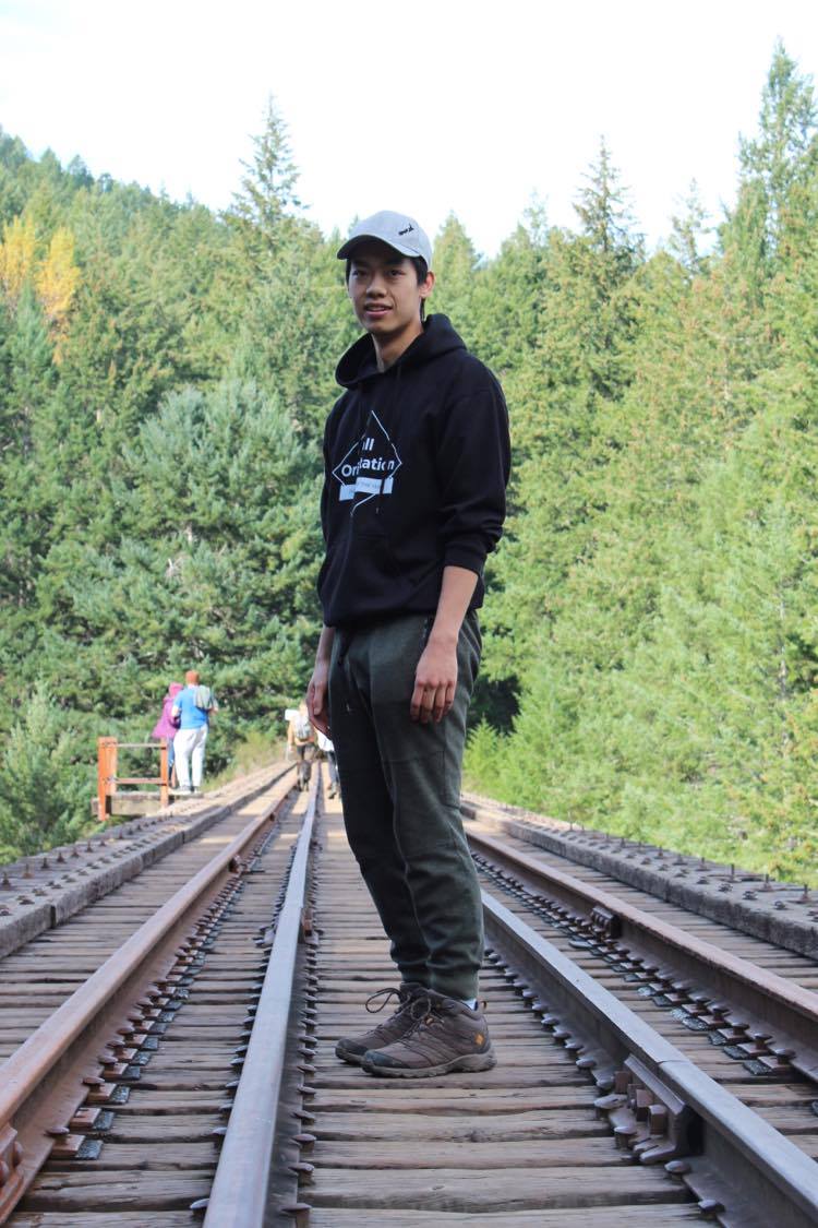 Matthew Zee standing on some old train tracks.