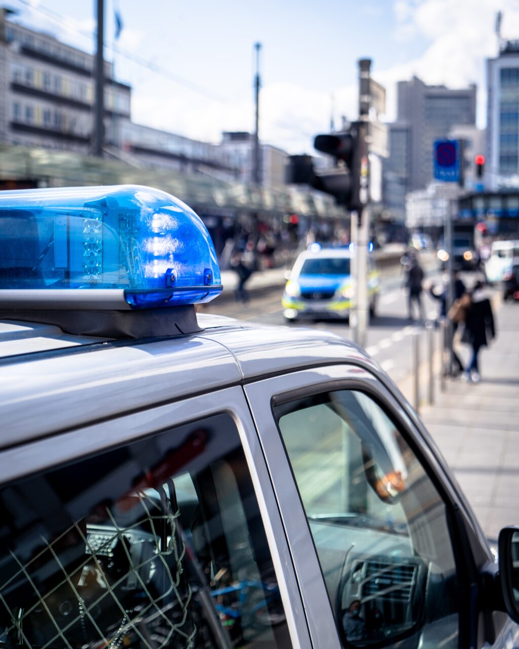 photo of police car siren with city street in background