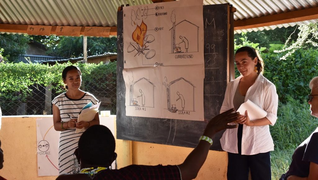 Carleton University students Clarissa Garcia (BCom/20) and Tatum Deitrich (BID/20) explain how the Moshi Inje Stove works to community members in Longido, Tanzania.