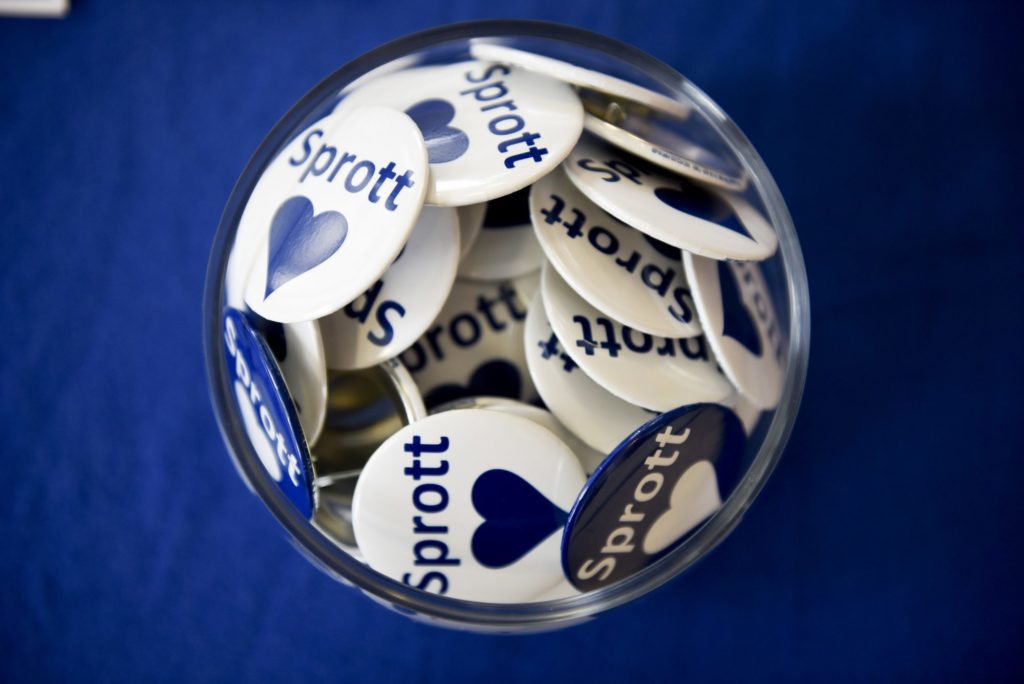 a bowl of pins that say Sprott Love