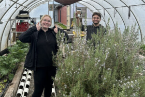 Two Carleton students in a greenhouse