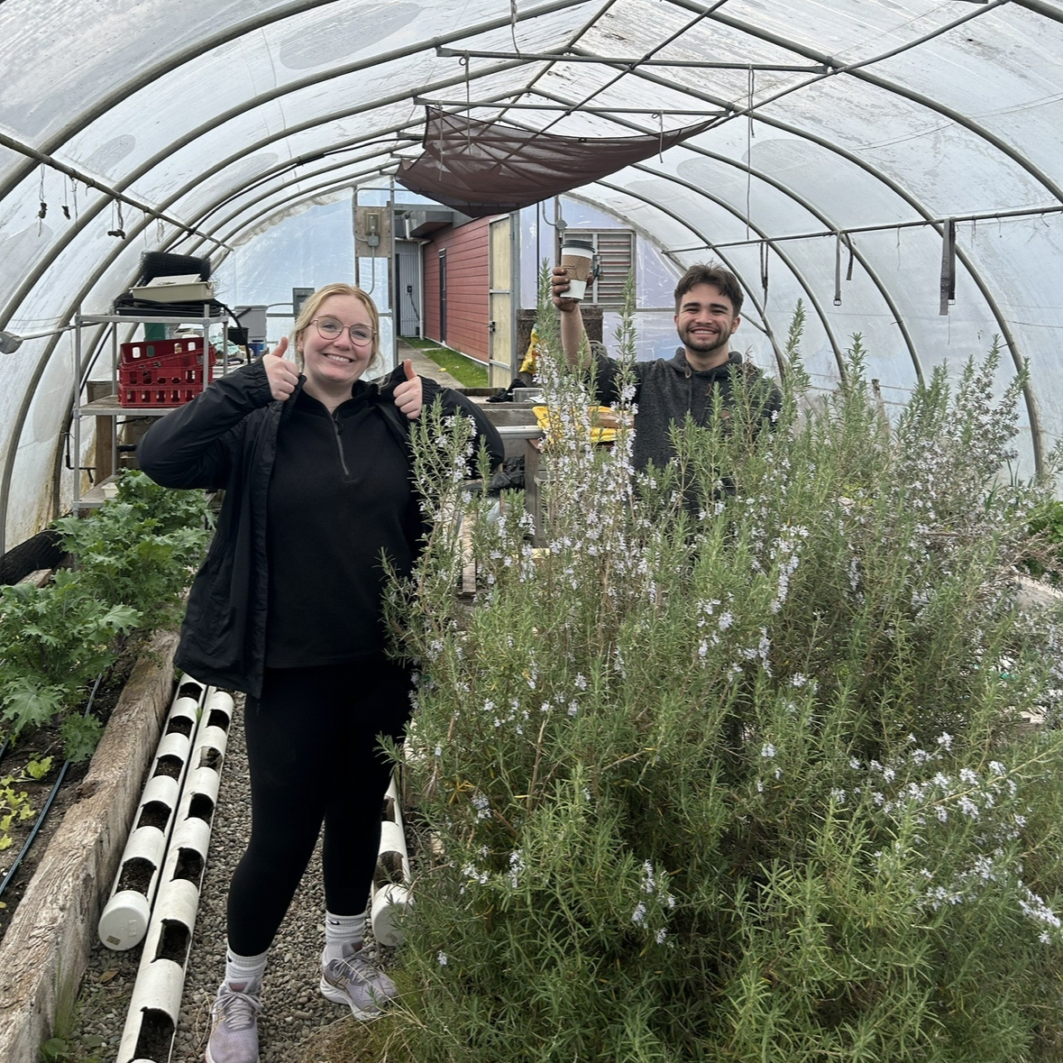 Two Carleton students in a greenhouse