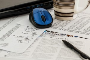 computer mouse and coffee cup on tax papers